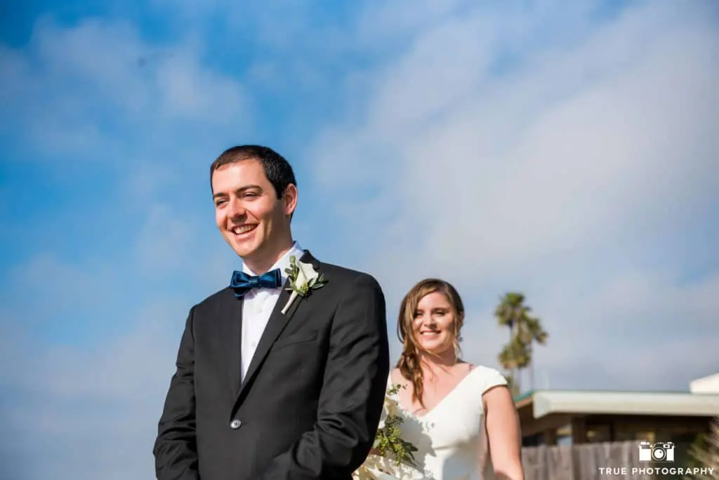 The groom waits for the bride to tap his shoulder, for the First Look reveal.