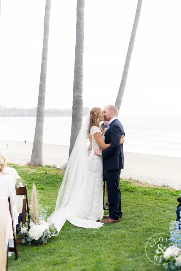 The bride and groom seal their vows with a kiss overlooking La Jolla Shores.