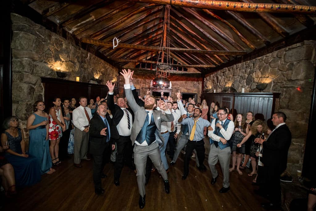 Bride and groom laughing during a wedding toss tradition at their reception